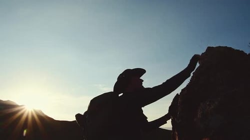Man Climb Up Cliff On Sunset