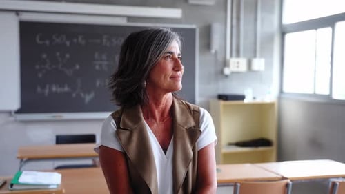 A Teacher Stands Alone in an Empty Classroom Gazing Thoughtfully Out of the Window