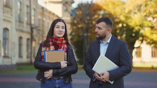 Male Teacher and Female Student Speaking Outside