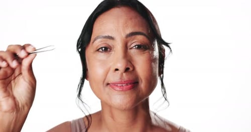 Face, plucking eyebrows and smile of woman in studio for beauty treatment or grooming routine