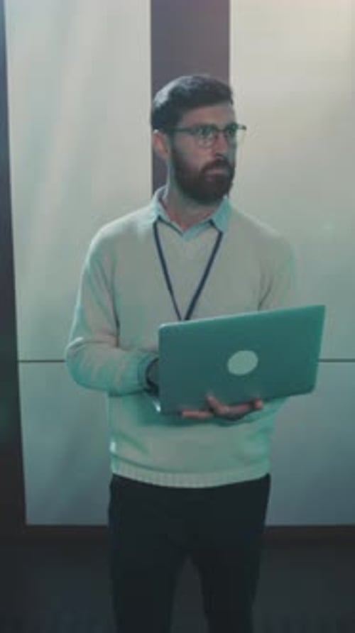 Un técnico de TI cualificado que lleva gafas examina los racks de servidores iluminados para detectar posibles problemas