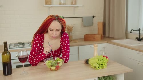 Woman Eats Salad and Drinks Wine