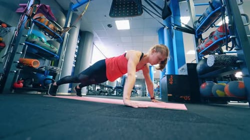 Woman Doing Pushups in Modern Gym