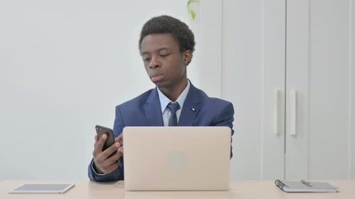Young Adult in Suit Using Smartphone in Office