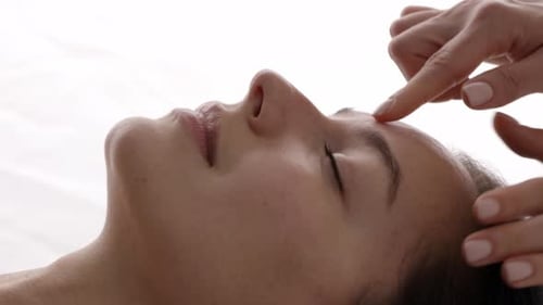 Close-up of the beautiful young woman receiving a quality facial massage.