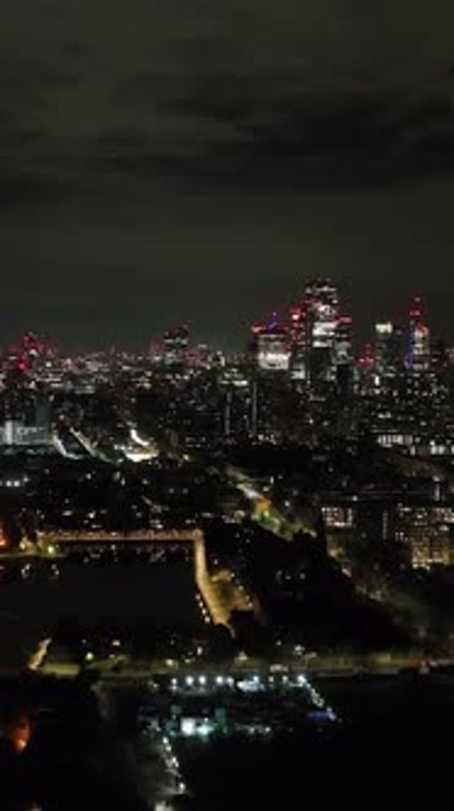 Vertical drone shot of traffic in Shadwell, Illuminated downtown London background