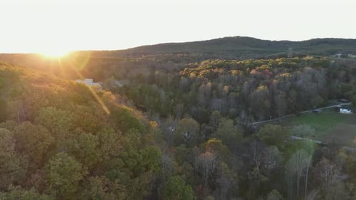 Golden Sunset Over Lush Green Mountains and Dense Forest Landscape
