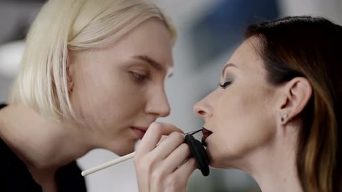 Careful Makeup Artist Applying Color on Female Lips Pro Makeup Artist Works in Beauty Studio
