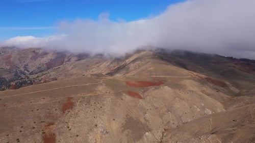 Cordillera de Grammeni Oxia con sombras en terreno rocoso y densas nubes cercanas