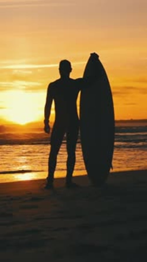 Silhouette of a Fit Guy Standing on the Beach with