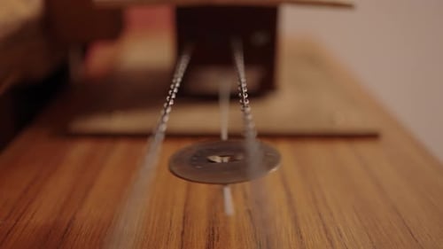 Clock Pendulum Swinging Back and Forth on Wooden Surface