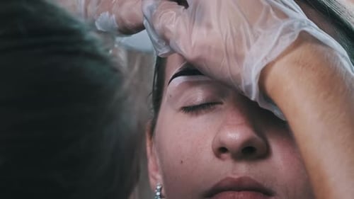 Beautician Applies Dark Tint to Eyebrows Close Up