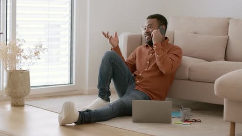 Man Talking on Cell Phone While Sitting on Floor