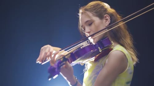 Woman Playing Purple Electric Violin on Stage