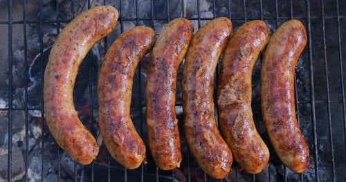 Delicious juicy sausages, cooked on the grill with a fire.