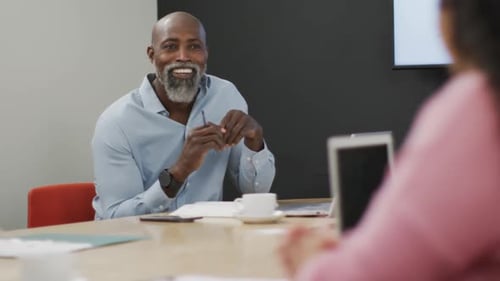 Happy diverse business people discussing work during meeting at office