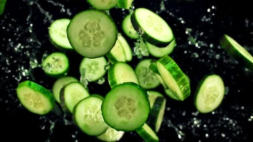 Cucumbers Falling in Slow Motion Against Black Backdrop