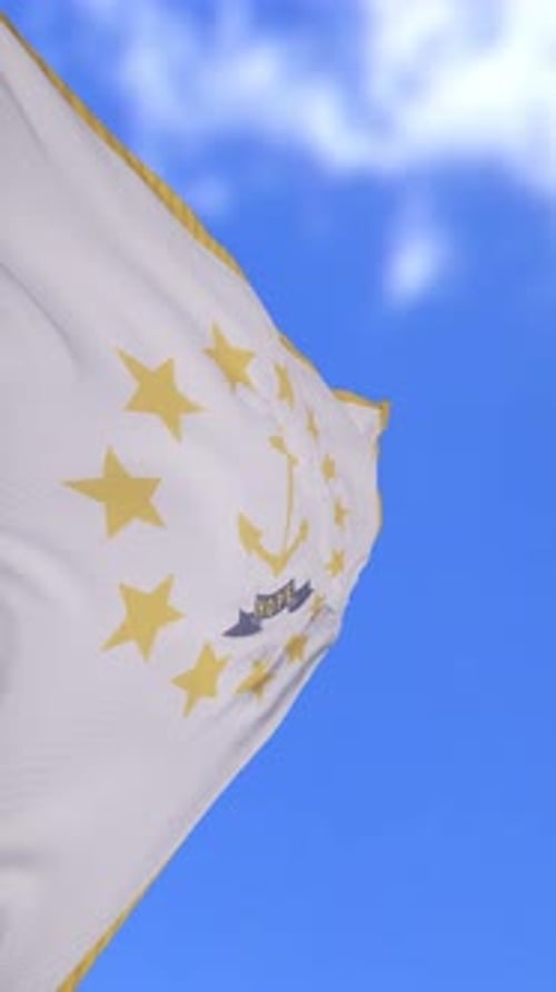 Drapeau du Rhode Island agitant contre un ciel bleu vif