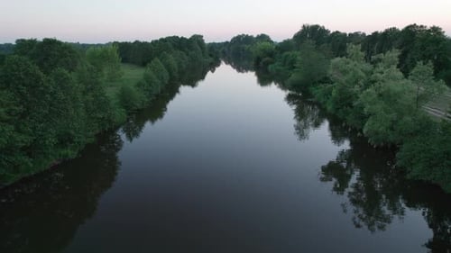 Low drone flight over the river at sunset. Drone Shot 4K.