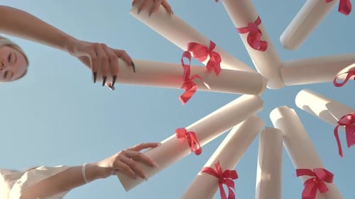 Graduates Join Their Diplomas in a Circle Against the Sky