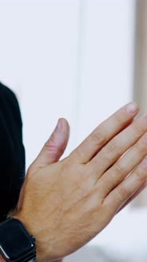 Male hands in praying position. Unrecognized man in black t-shirt rubbing his hands nervously.