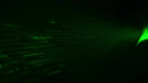 Grüne Laserstrahlen, die in Rauch auf schwarzem Hintergrund leuchten