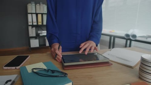 Unrecognizable Businessperson Working on Report on Tablet