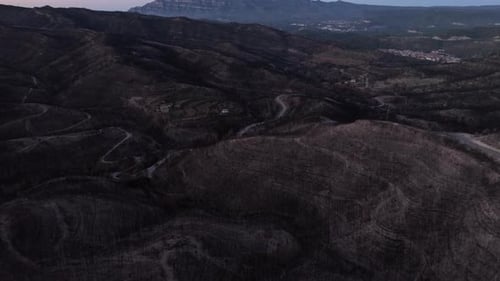 Twilight aerial view over hillside burned remains of forest fire natural disaster