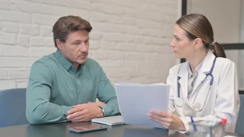 Doctor Discussing Medical Report with Patient in Clinic