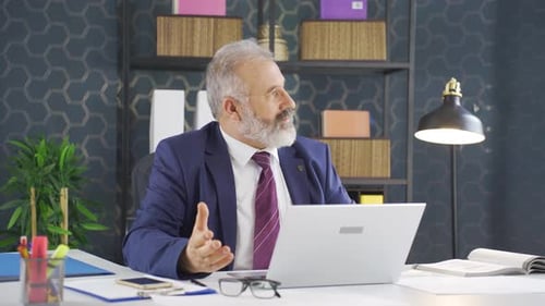Senior Man in Suit Using Laptop in Office