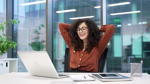 Happy businesswoman finished work on laptop computer while sitting at workplace in a business office