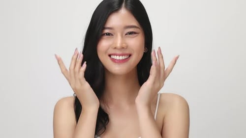 Studio shot of Beautiful young Asian woman with clean fresh skin on white background.