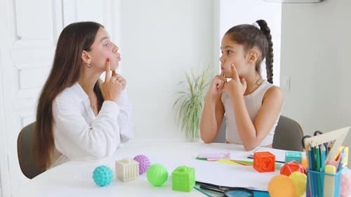 Speech Therapist Guides Child Through Articulation Exercises at Therapy Session in Bright Modern