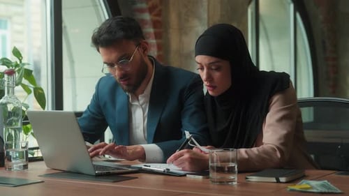 Concerned Colleagues Reviewing Documents in Office Together
