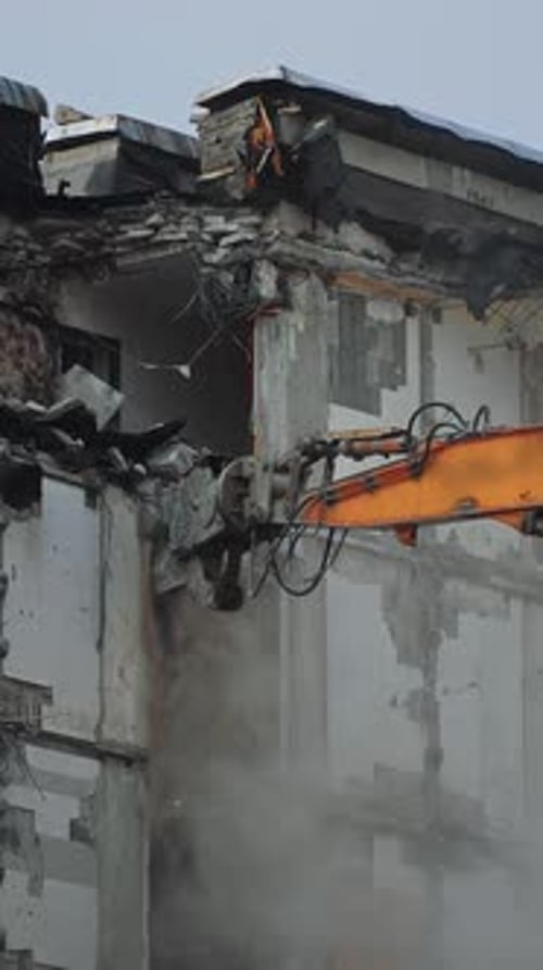 Excavator Demolishing Building on a Construction Site