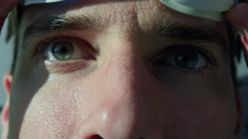 Male caucasian swimmer putting on the swimming glasses