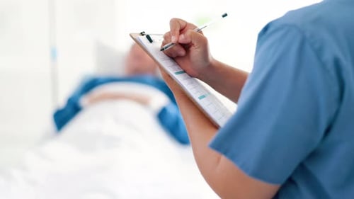 Nurse Taking Notes on Patient in Hospital Room