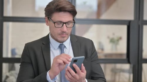 Portrait of Businessman using Phone in Office