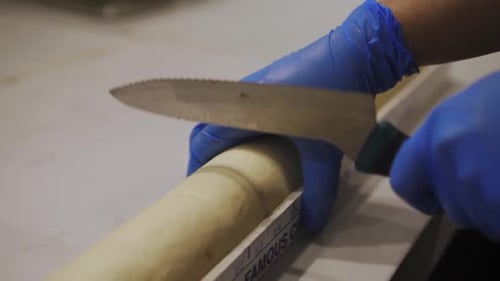 Baker Measuring And Marking The Rolled Dough With The Knife. close up