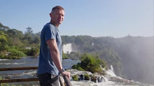 Man Admiring Beautiful Tropical Waterfall Landscape