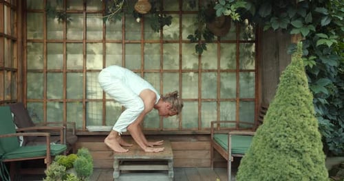 Woman Practices Yoga Handstand in Covered Outdoor Space