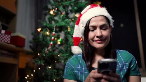 Woman With Santa Hat Using Mobile Phone