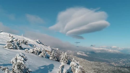 Majestic Lenticular Cloud Formation Over Snow Covered Mountain Landscape
