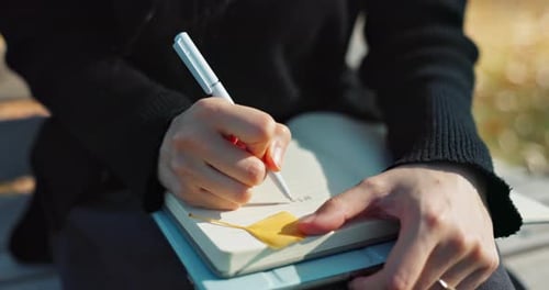 Closeup, writing and notes in park with hands, person and journalist with ideas