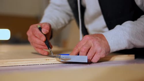Close Up Shoot of Carpenter Measuring and Marking Wooden Board with Ruler and Pencil During