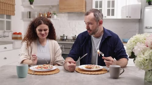 Couple Enjoying Meal Together at Kitchen Table