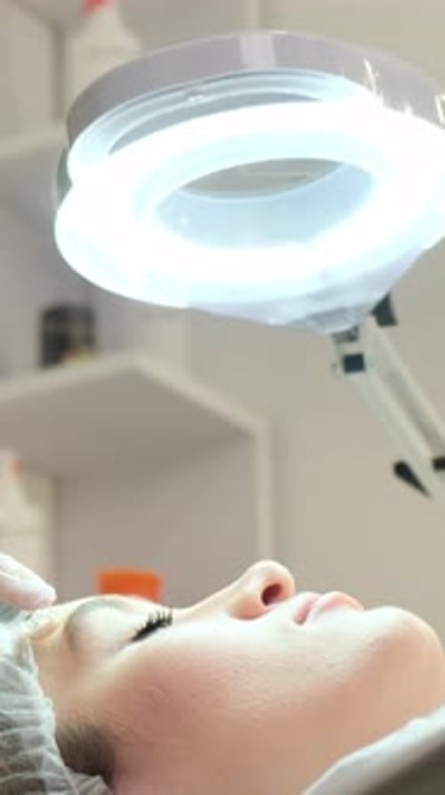 Woman Receiving Facial Treatment in Brightly Lit Room