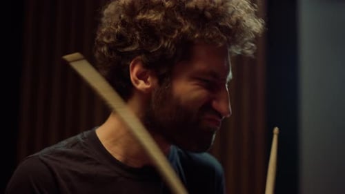 Expressive Male Artist Shaking Head at Rock Music Concert. Curly Drummer Playing
