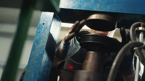 Worker Adjusting Machinery in a Workshop