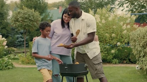 An African Dad Cooks Grill Vegetables for His Multiethnic Family